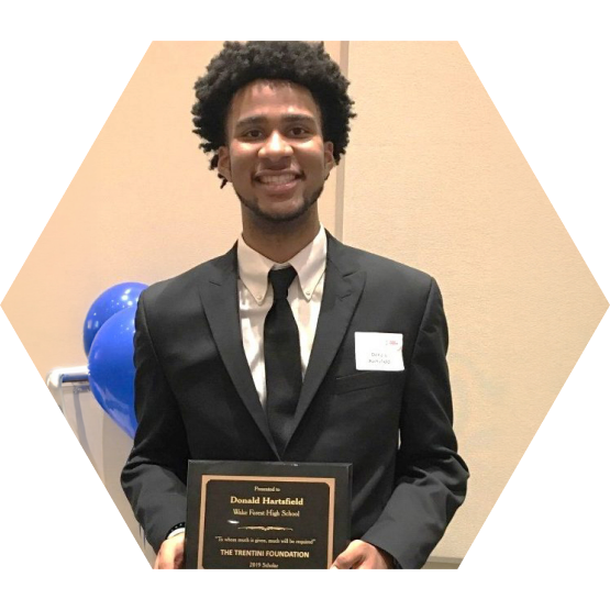Donald Hartsfield holding his academic scholarship award