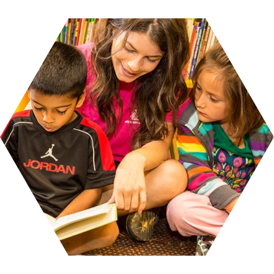 Club staff helping children read together